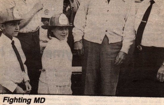 An old newspaper clipping with Dom as a child wearing a fireman's helmet.